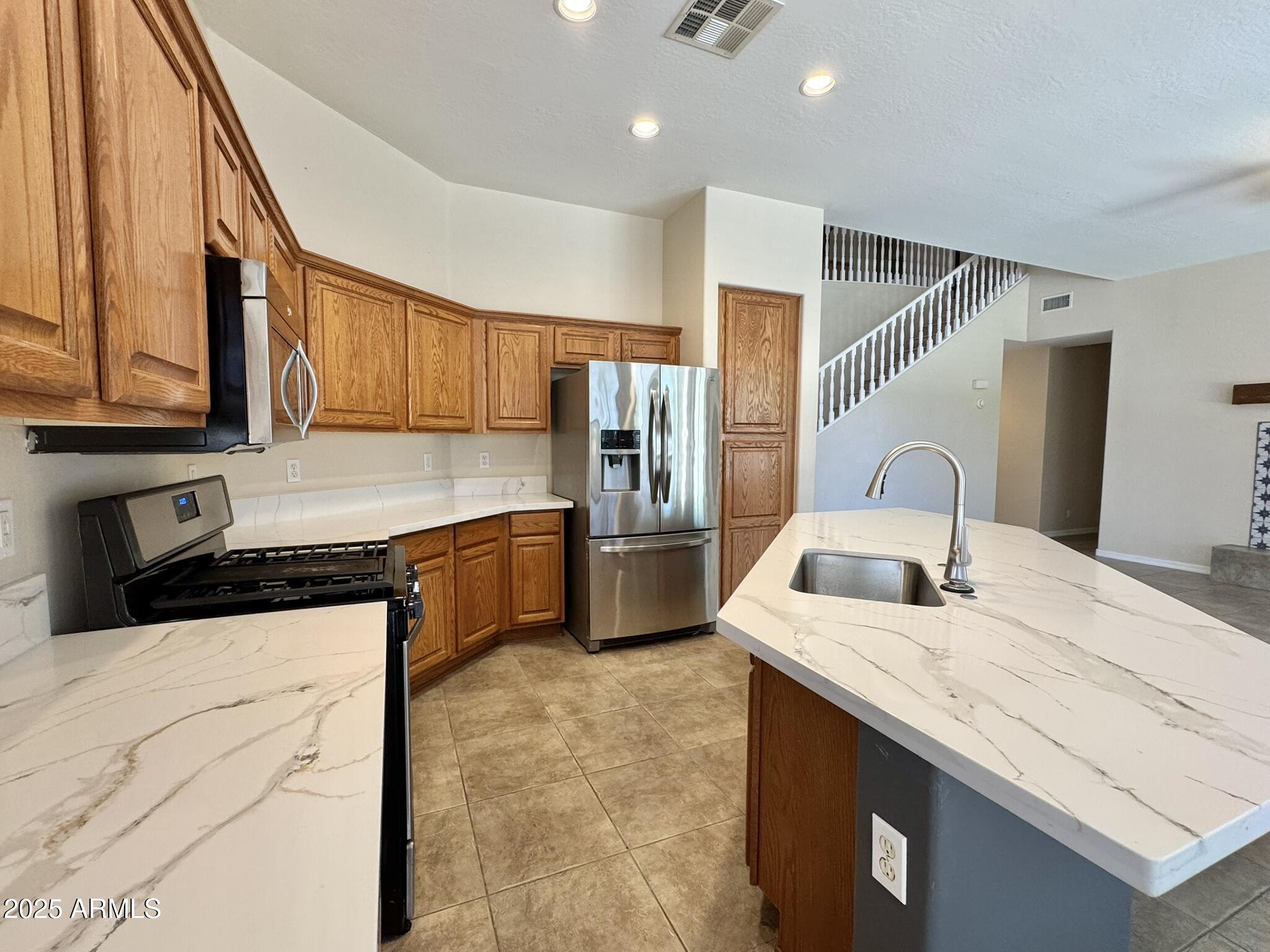2671 South Dragoon Drive Chandler, AZ 85286 - Photo 7 of 41 a kitchen with granite countertop a sink stove and refrigerator