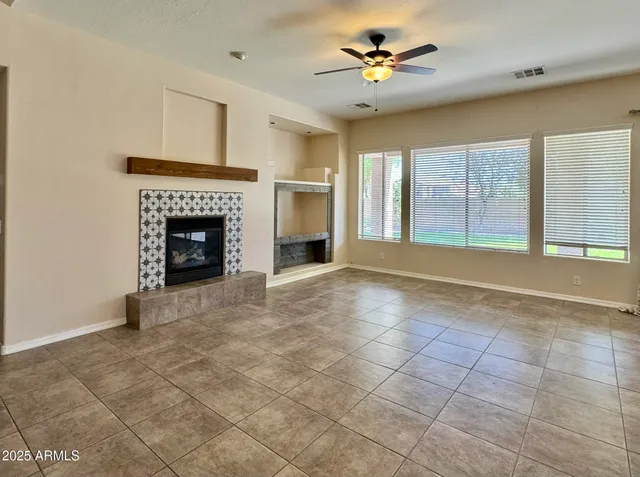 a view of an empty room with a fireplace and a window