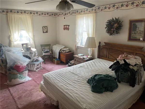 a bedroom with a bed mirror and window