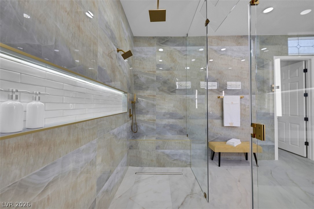 5015 Rivedro Street Las Vegas, NV 89135 - Photo 37 of 91 Marble-clad shower with gold fixtures and integrated shelving creates a spa-like retreat.