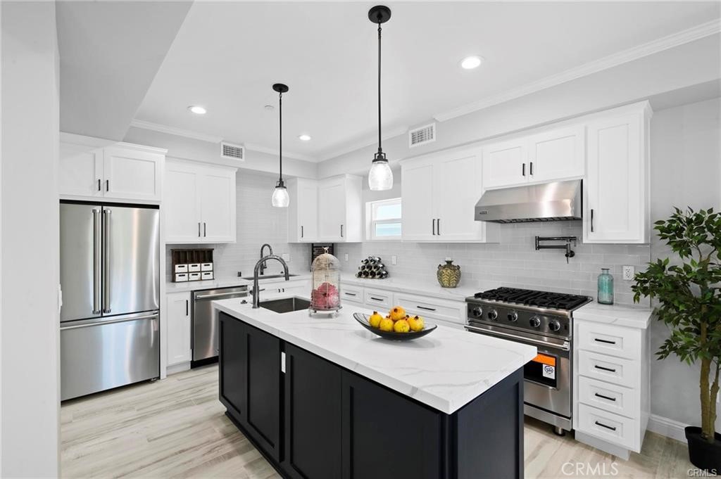 112 Van Nuys Avenue Oxnard, CA 93035 - Photo 12 of 58 a kitchen with a refrigerator a stove a microwave and wooden floor