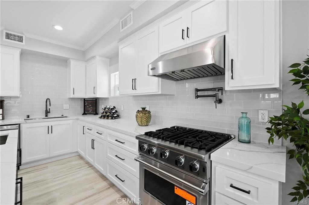 112 Van Nuys Avenue Oxnard, CA 93035 - Photo 17 of 58 a kitchen with white cabinets and appliances