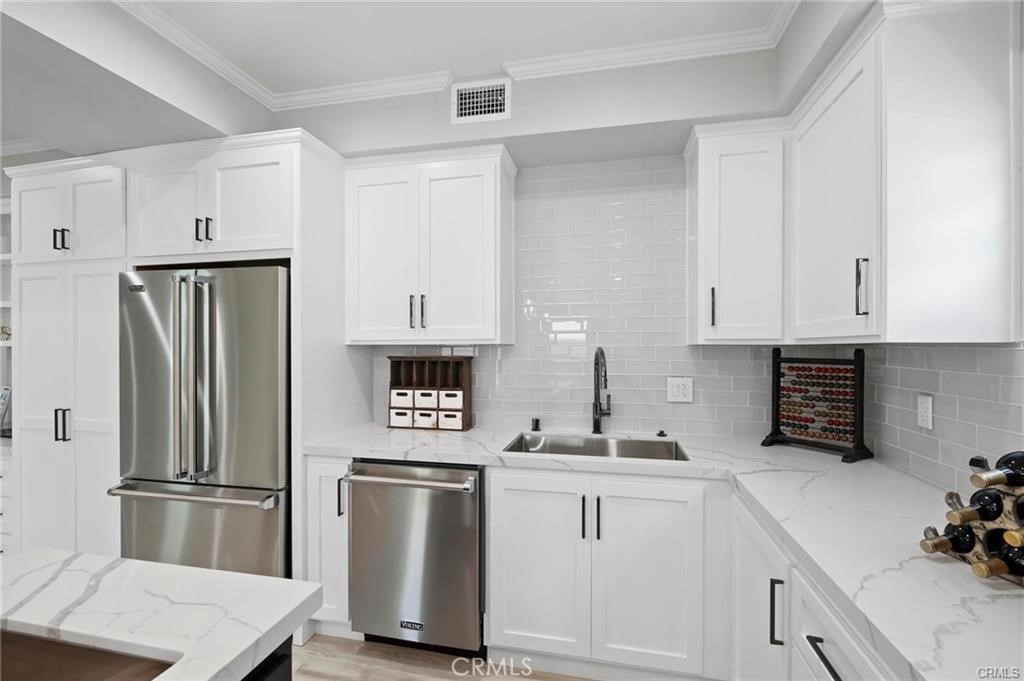 112 Van Nuys Avenue Oxnard, CA 93035 - Photo 18 of 58 a kitchen with refrigerator and cabinets