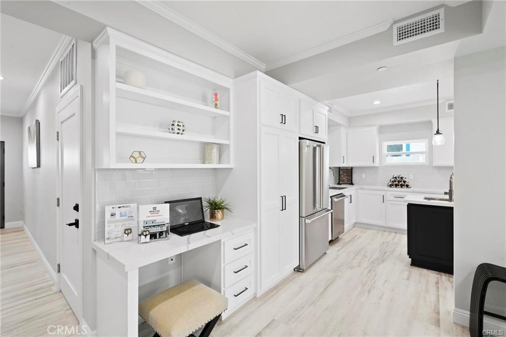 112 Van Nuys Avenue Oxnard, CA 93035 - Photo 20 of 58 a kitchen with white cabinets and stainless steel appliances