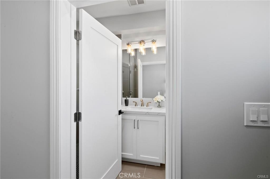 112 Van Nuys Avenue Oxnard, CA 93035 - Photo 30 of 58 a en suite bathroom with a sink a mirror and a shower