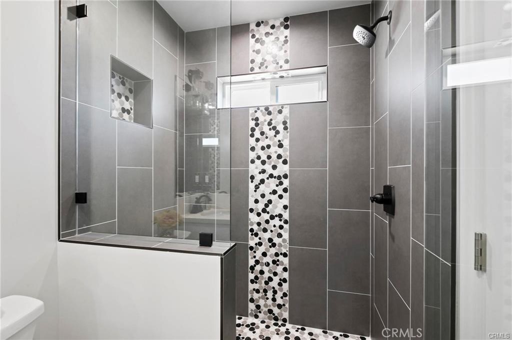 112 Van Nuys Avenue Oxnard, CA 93035 - Photo 47 of 58 a bathroom with a shower a mirror and a sink