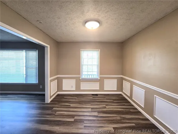 a kitchen with stainless steel appliances granite countertop a refrigerator a stove and a sink with wooden floor