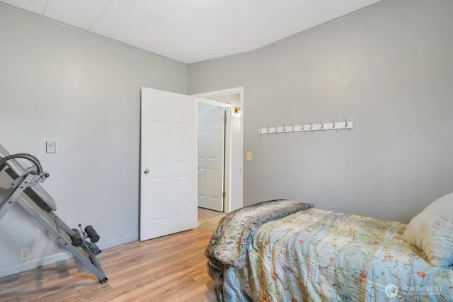 a bedroom with a bed and a wooden floor