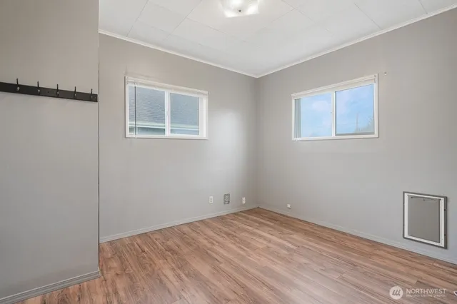 a view of empty room with wooden floor and fan