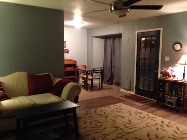 a living room with furniture a dining table and chairs with wooden floor