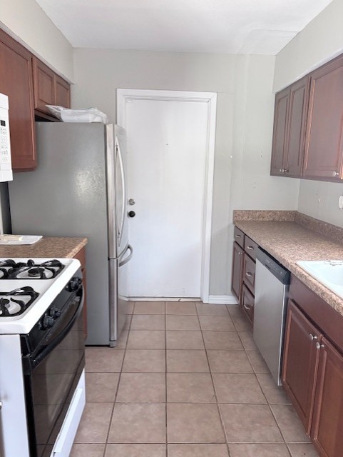 1917 Castle Gate Circle San Marcos, TX 78666 - Photo 7 of 21 Kitchen with stainless steel appliances, light tile patterned floors, and light countertops