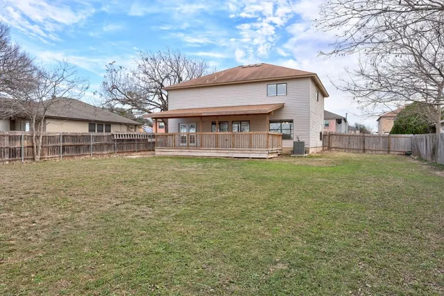 a front view of house with yard and trees in the background