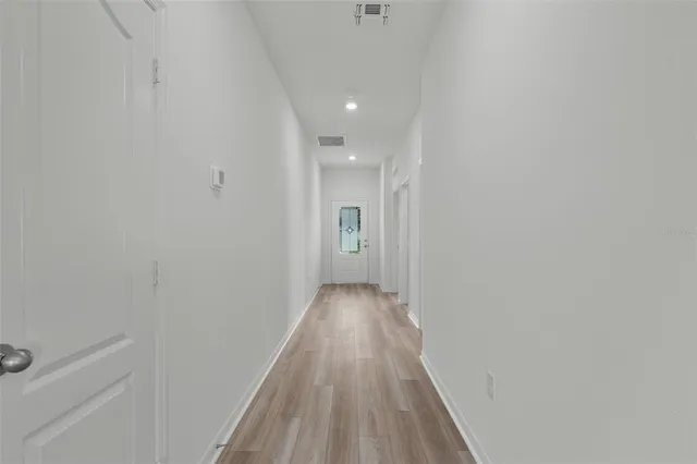 a view of a hallway with wooden floor
