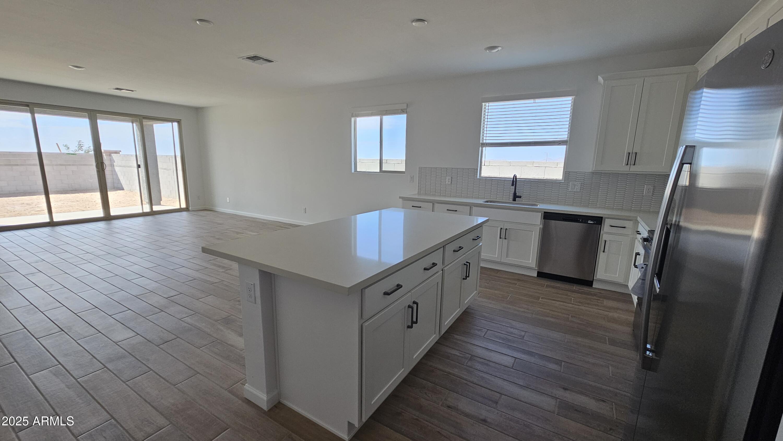 6443 East Fiddleneck Street San Tan Valley, AZ 85140 - Photo 12 of 26 a kitchen with stainless steel appliances granite countertop a sink stove and refrigerator