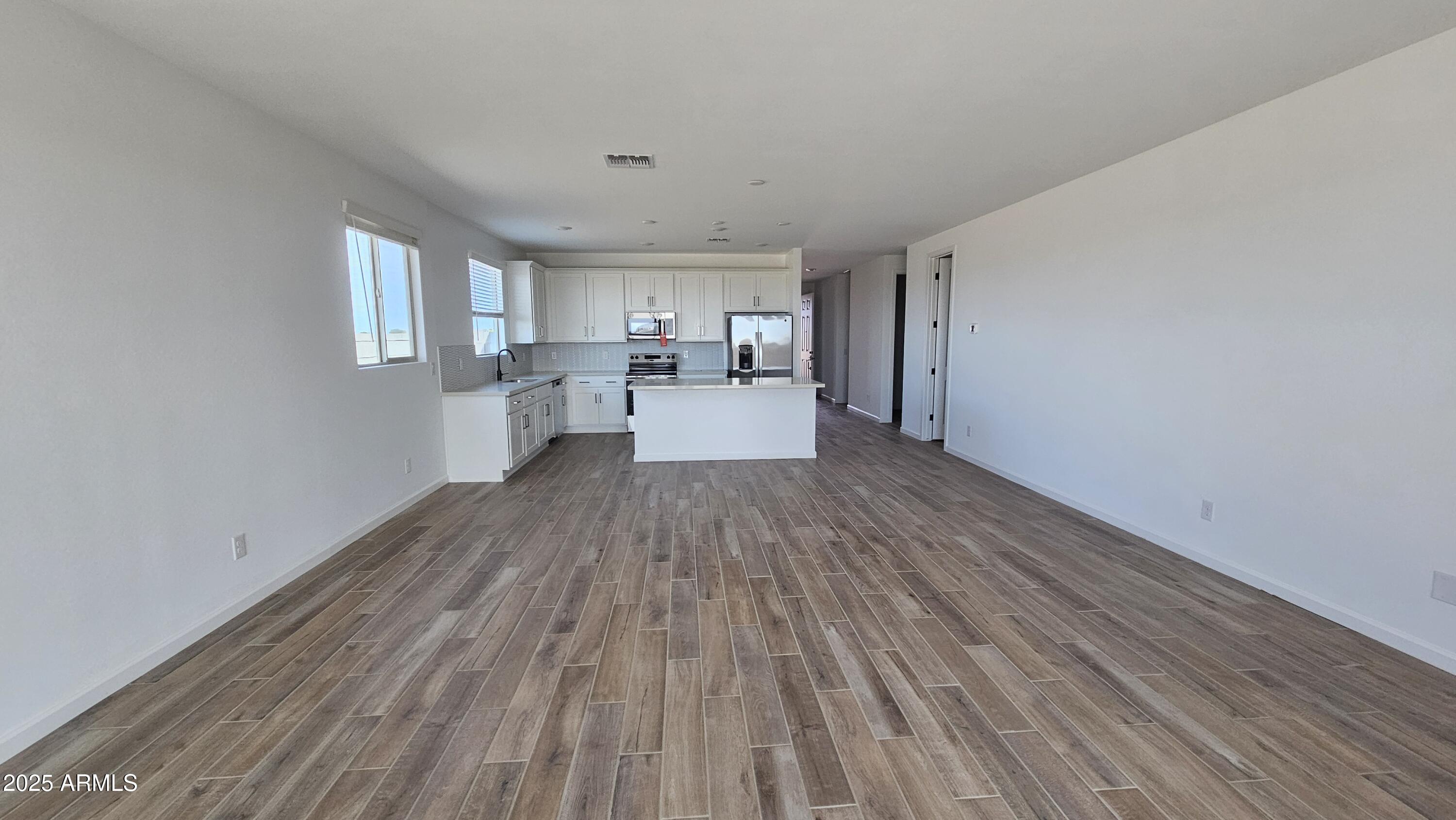 6443 East Fiddleneck Street San Tan Valley, AZ 85140 - Photo 14 of 26 a view of a kitchen with wooden floor and electronic appliances