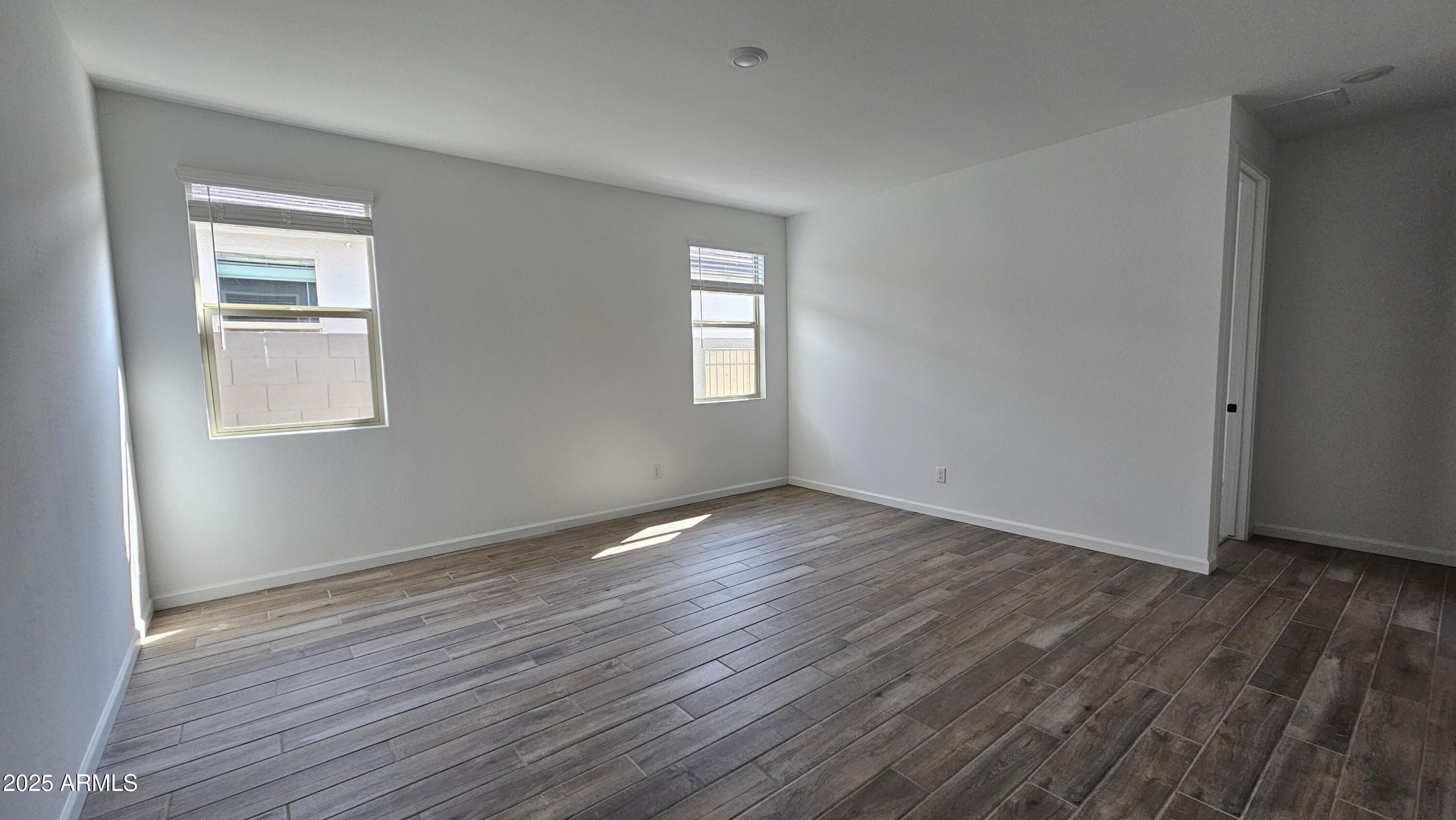 6443 East Fiddleneck Street San Tan Valley, AZ 85140 - Photo 9 of 26 an empty room with wooden floor and windows