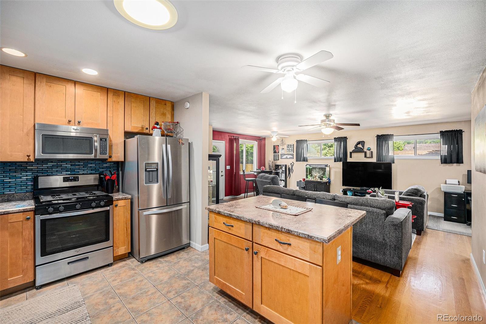 8601 Cedar Lane Westminster, CO 80031 - Photo 10 of 20 a kitchen with kitchen island white cabinets and refrigerator