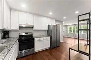 a kitchen with stainless steel appliances granite countertop a stove a refrigerator and a cabinets