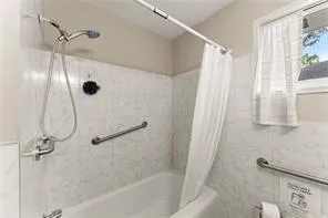 a bathroom with a shower and a bath tub