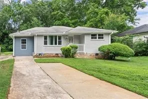 a front view of a house with a yard and potted plants