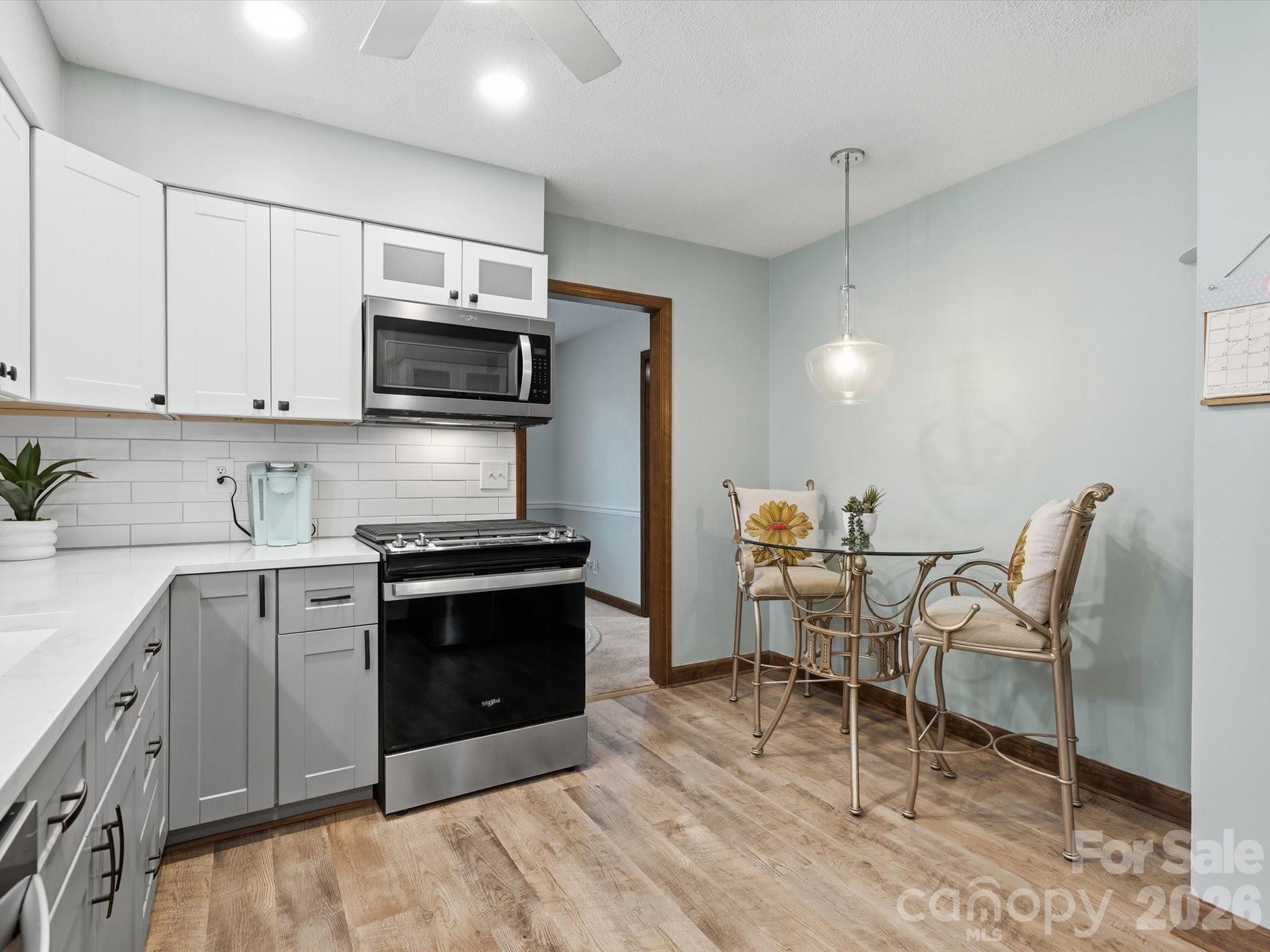 107 Friendfield Drive Fort Mill, SC 29715 - Photo 12 of 40 a kitchen with stainless steel appliances a stove a sink cabinets and a dining table