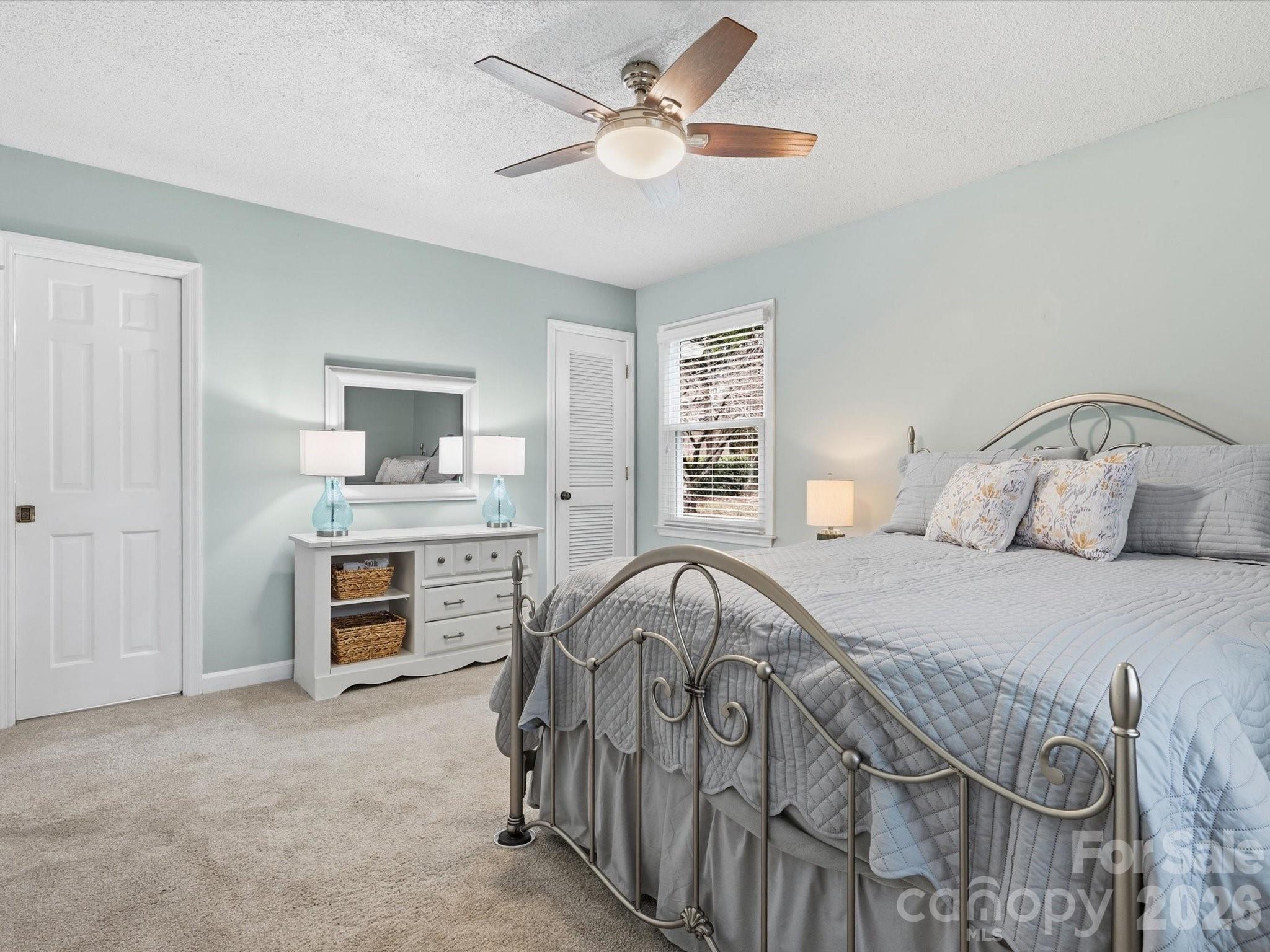 107 Friendfield Drive Fort Mill, SC 29715 - Photo 21 of 36 a bedroom with a bed and a chandelier