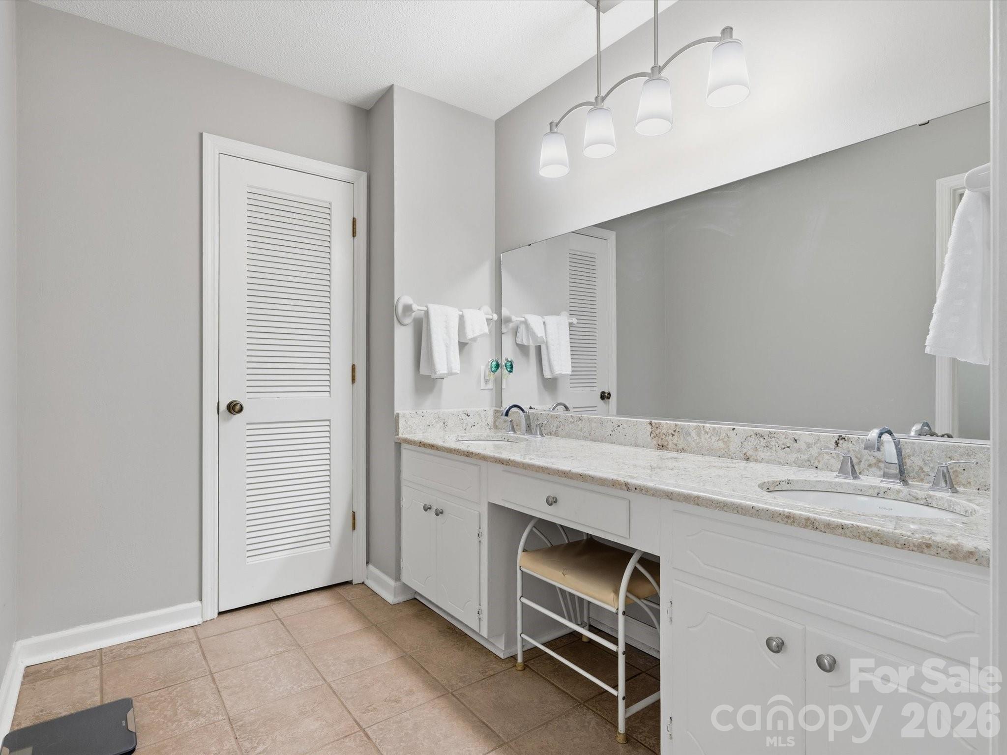 107 Friendfield Drive Fort Mill, SC 29715 - Photo 28 of 36 a spacious bathroom with a granite countertop sink a mirror and a vanity