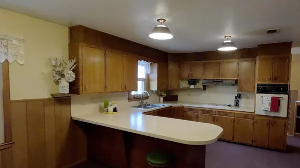 a kitchen with a sink refrigerator and cabinets
