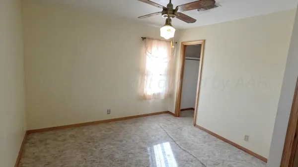 an empty room with window and wooden floor