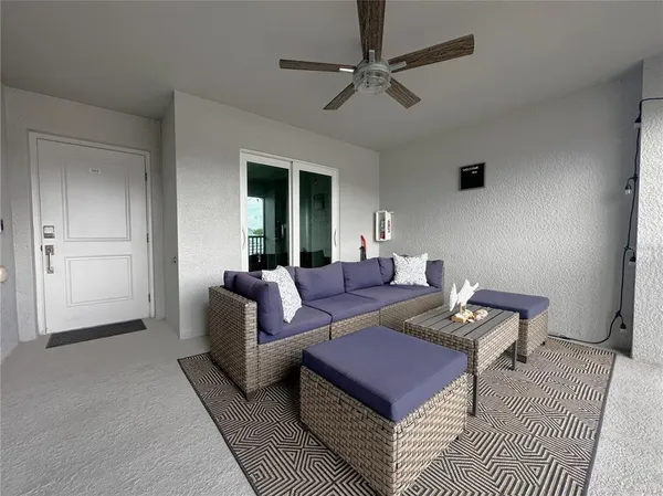 a living room with furniture a ceiling fan and a rug