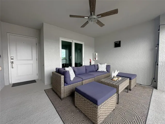 a living room with furniture a ceiling fan and a rug