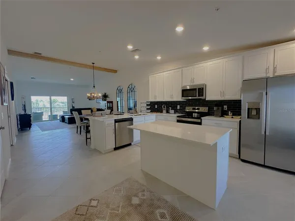 a kitchen with stainless steel appliances a refrigerator sink a microwave a stove and cabinets