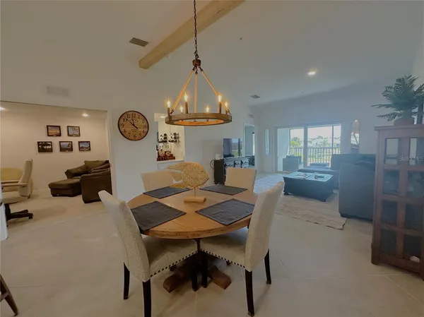 a living room with couches a dining table and a clock on the wall