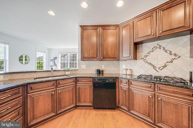 a view of kitchen with stainless steel appliances granite countertop a stove a sink a dining table and chairs