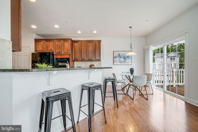 a living room with furniture kitchen view and a wooden floor