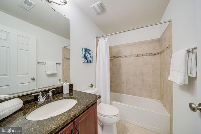 a spacious bathroom with a tub sink and mirror