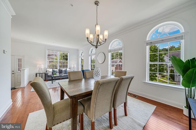 a view of a dining room with furniture a chandelier and wooden floor