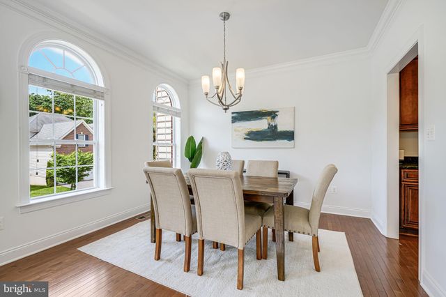 a view of a dining room with furniture a chandelier and wooden floor