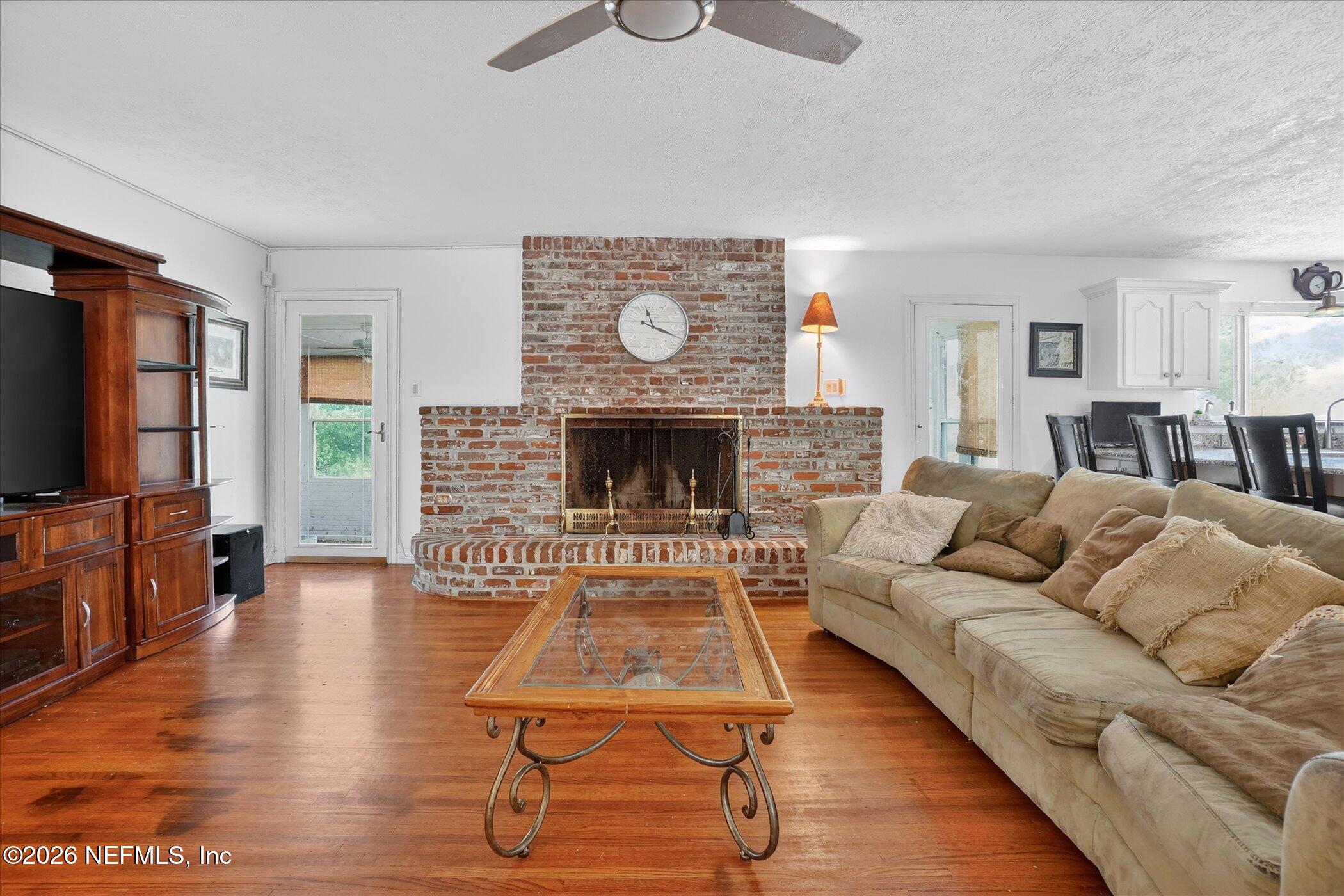 4242 Hillwood Road Jacksonville, FL 32223 - Photo 21 of 36 a living room with furniture flat screen tv and a fireplace