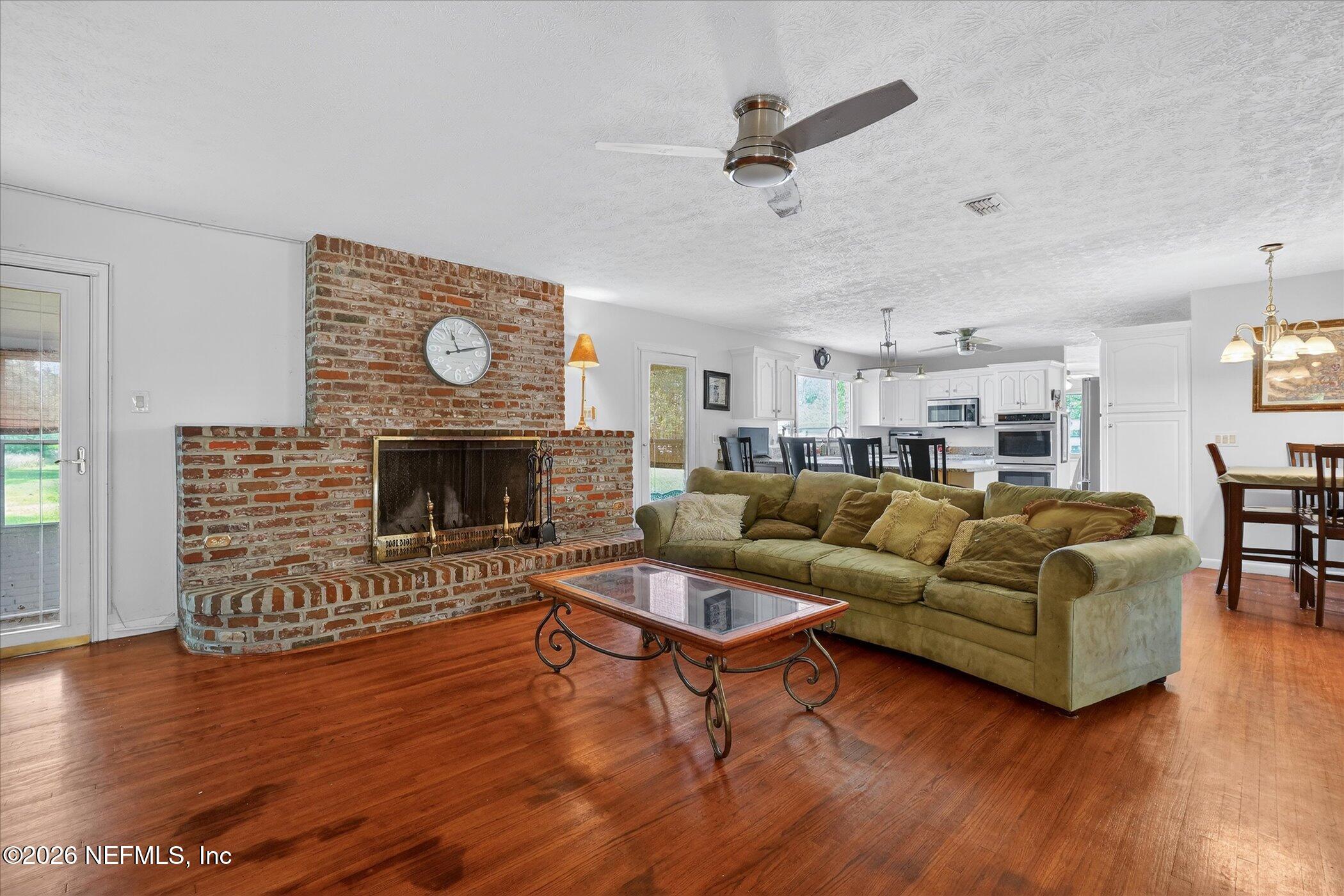 4242 Hillwood Road Jacksonville, FL 32223 - Photo 23 of 36 a living room with furniture wooden floor and a fireplace