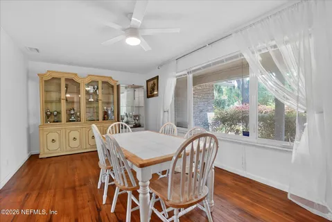 a bedroom with a bed a chandelier and potted plant on the wooden floor