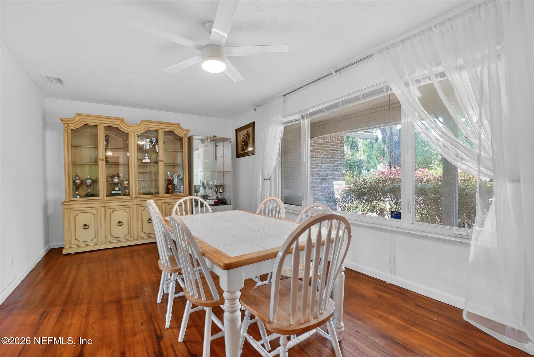 4242 Hillwood Road Jacksonville, FL 32223 - Photo 29 of 36 a view of a dining room with furniture window and wooden floor