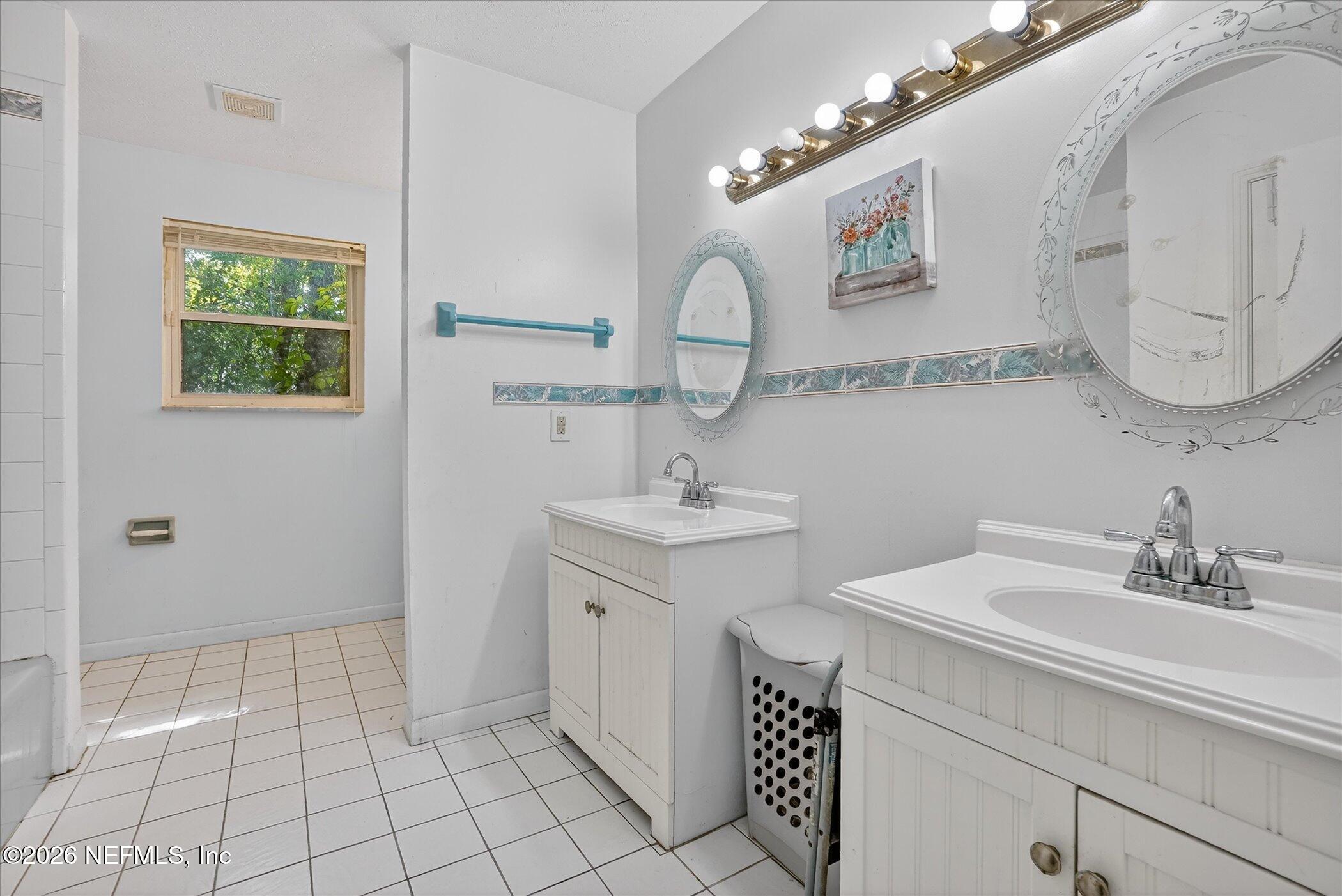 4242 Hillwood Road Jacksonville, FL 32223 - Photo 34 of 36 a bathroom with a sink mirror and vanity