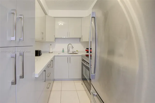 a kitchen with white cabinets and white appliances
