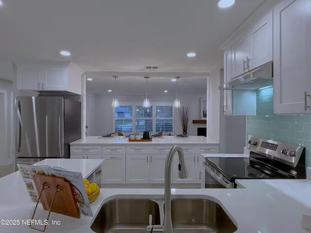a kitchen with stainless steel appliances granite countertop a sink and a refrigerator
