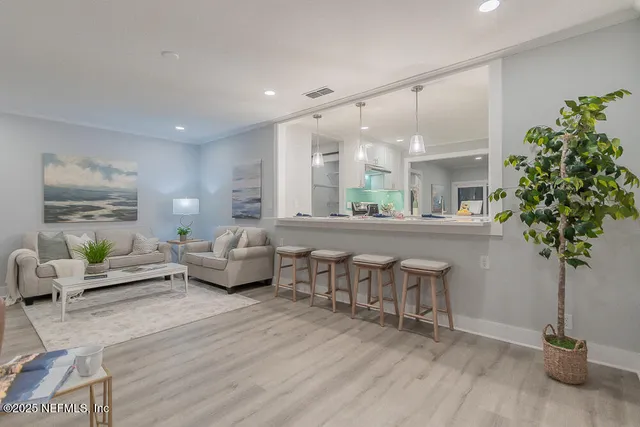 a living room with furniture potted plant and a chandelier