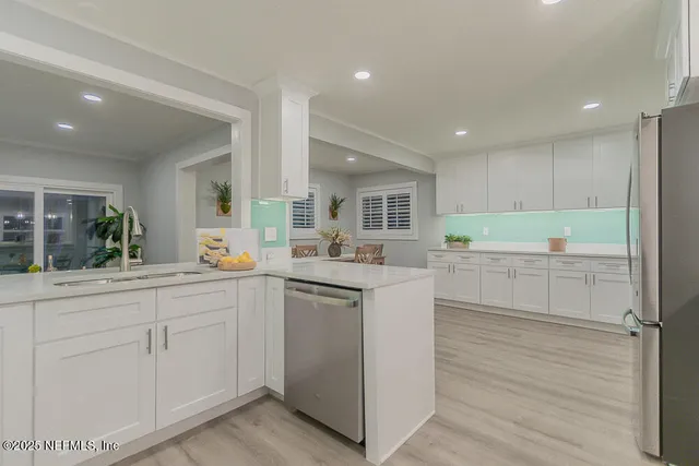 a kitchen with white cabinets and sink