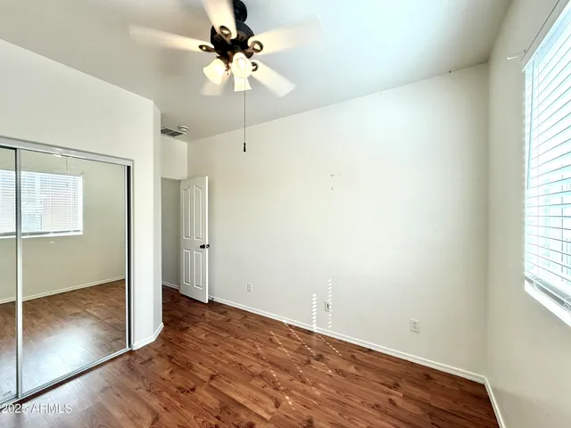 an empty room with fan and windows