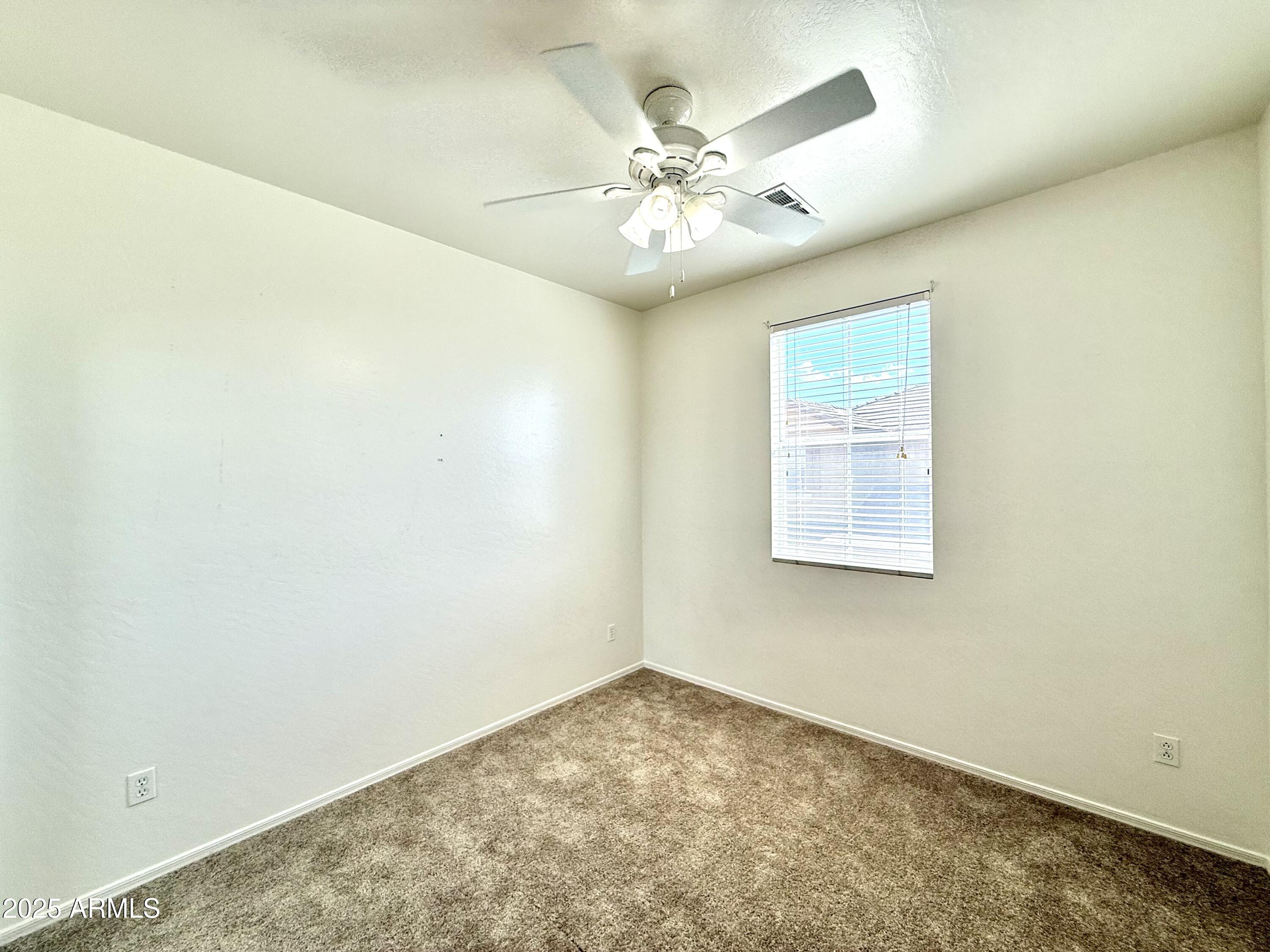 34924 North 30th Avenue Phoenix, AZ 85086 - Photo 13 of 20 an empty room with a chandelier fan and windows