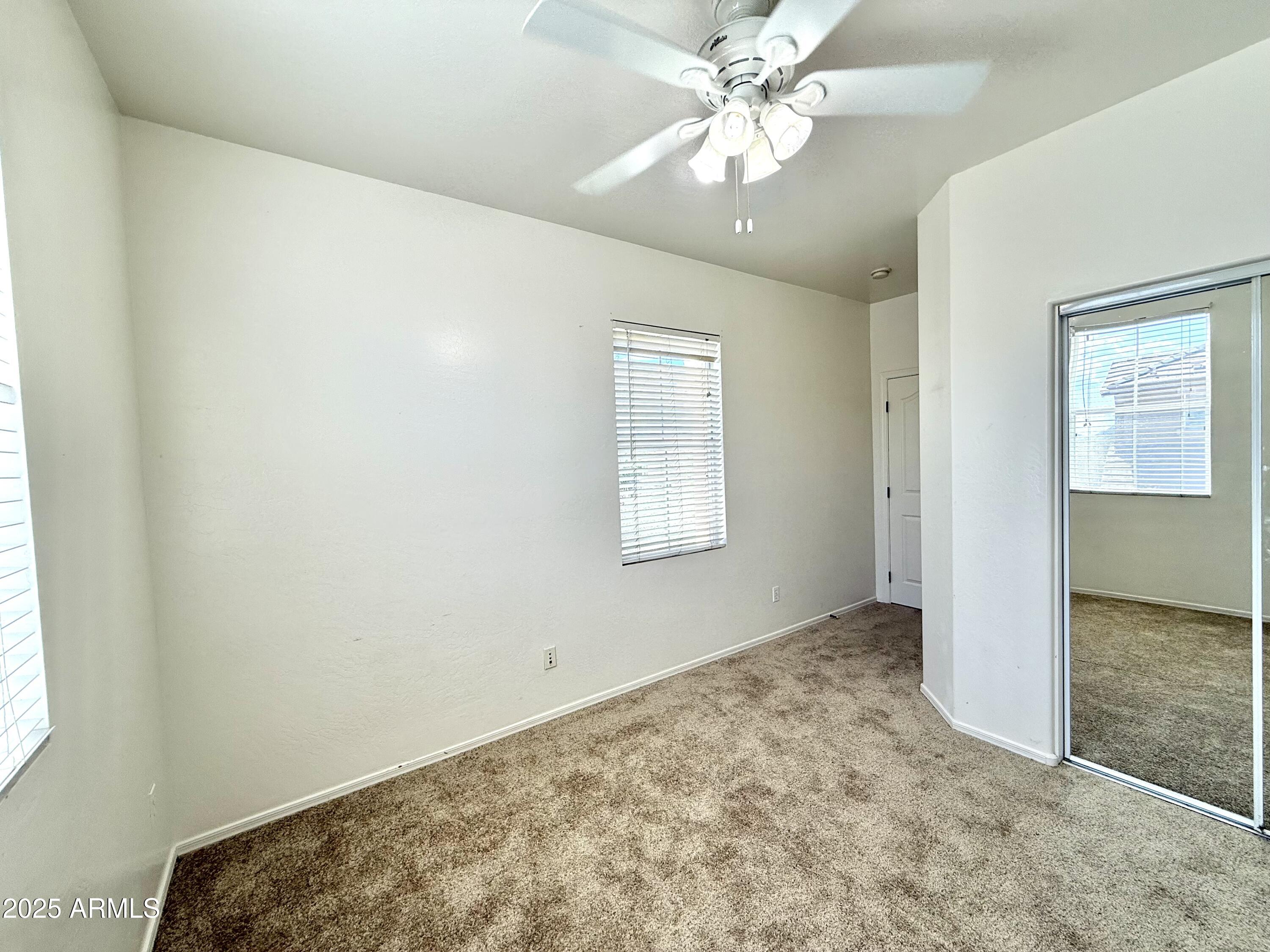 34924 North 30th Avenue Phoenix, AZ 85086 - Photo 14 of 20 an empty room with a chandelier fan and windows